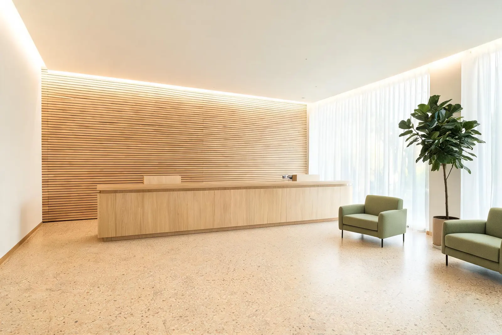 L'accoglienza di Nova Medical: parete a doghe di rovere chiaro, bancone continuo in legno massello, pavimento in terrazzo caldo e luce naturale filtrata da tende in lino.